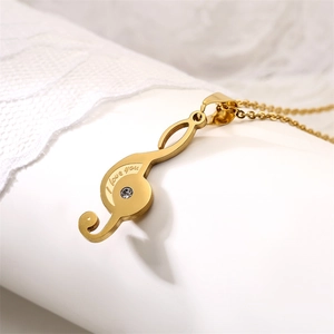 Detail of gold treble clef pendant engraved with I love you and set with a small zircon