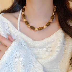 Detailed view of resin amber beads and gold metal accents on a vintage collar necklace