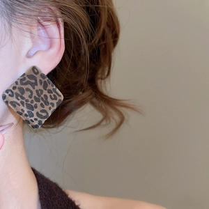 Close-up of vintage square leopard print flocking drop earrings worn on earlobe