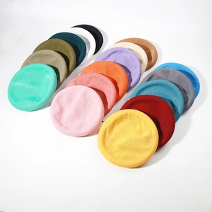 Detailed grid of knitted berets in a variety of vibrant colors on white background