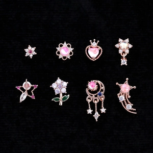 Détail de 8 piercings d'oreille en or rose avec zircons et fleurs sur velours