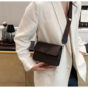 Detailed view of dark brown minimalist crossbody bag with wide adjustable shoulder strap