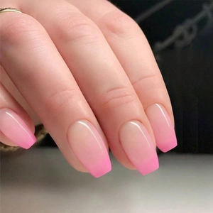 Close-up detail of gradient pink press-on nails in trapezoid shape with glossy finish