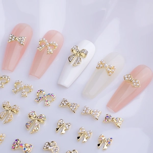 3D alloy bowknot nail art charms with pearls and rhinestones on elegant silk background