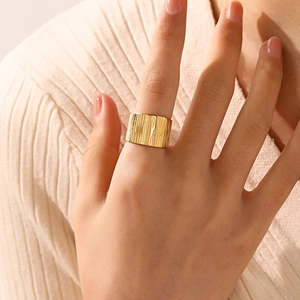 18K gold plated wide band geometric ring with textured bark finish on model's finger