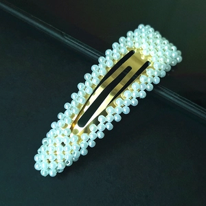 Close-up of golden BB hair clip with white pearls in a minimalist Korean style