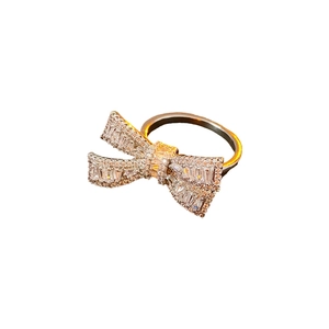 Polished silver bow ring with shimmering cubic zirconia stones on white background