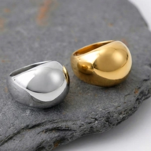 Polished chunky puffy dome ring in gold and silver finish on natural stone background