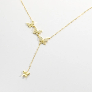 Detailed close-up of golden butterfly necklace with shimmering micro-pave zircons