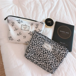 Detail view of floral makeup bags showing textured fabric and Time to Party woven label