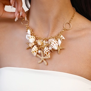 Close-up of golden nautical necklace with shells, starfish and pearls on a model