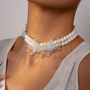 Detail of double-layer pearl choker featuring iridescent floral pendants and blue beads