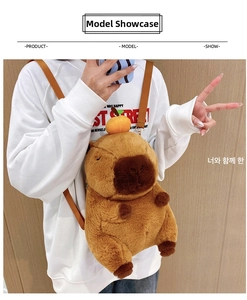 Detail view of the cute Capybara plush backpack with orange accessory on model