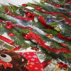 Dettaglio di arazzo natalizio con stampa di albero festivo e orsetto di peluche
