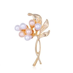 Detailed close-up of golden floral brooch featuring white and soft pink oval pearls