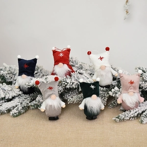 Set of six colorful plush Christmas gnomes hanging on festive pine branches
