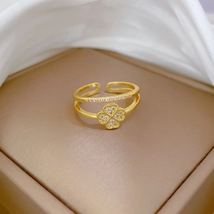 Macro view of gold-plated double-layer open ring featuring a sparkling zircon clover motif