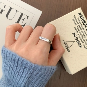 Detail of 925 sterling silver smile ring worn by model with minimalist warm aesthetic