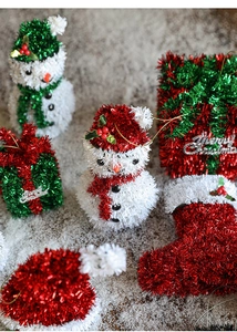 Macro shot of snowman, stocking, and gift box Christmas ornaments in festive red and green