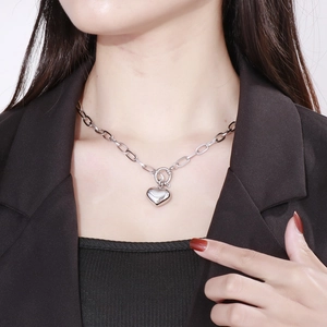 Detail of silver heart pendant necklace with thick chain links and toggle clasp