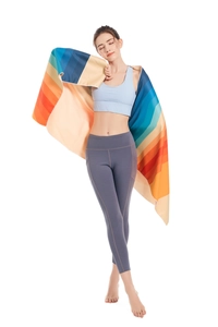 Detail of rainbow striped quick-dry beach towel draped over a fitness model in sports gear