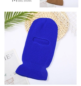 Royal blue knitted balaclava with single hole eye opening on textured straw mat