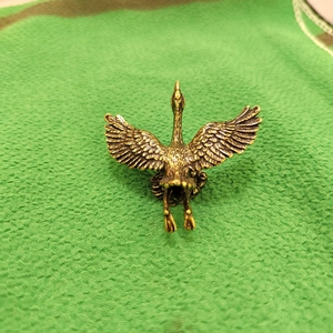 Detailed view of the vintage brass crane ornament showing intricate feather textures