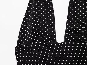 Detail of the deep V-neckline and polka dot pattern on the black fabric