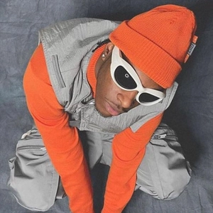 Detail view of orange streetwear outfit with Y2K sunglasses and tactical cargo vest
