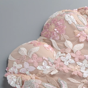 Detailed close-up of nude pink mesh dress featuring 3D floral embroidery and sequins