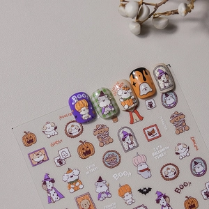 Detail of Halloween nail stickers featuring cute cartoon dogs in festive costumes
