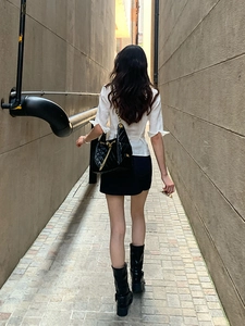 Photo de rue d'un sac en cuir matelassé noir avec une élégante bandoulière chaîne dorée