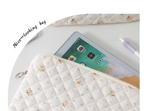 Close-up of floral quilted cotton iPad sleeve with metal zipper and soft fabric texture