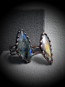 Macro detail of two labradorite rings with blue and gold flashes in antique bronze finish