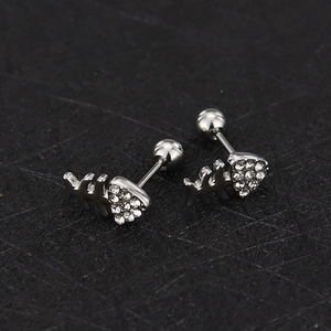 Detailed view of silver fishbone earrings with heart-shaped zircon stones and screw-back