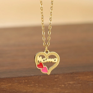 Détail du pendentif cœur doré avec lettrage Mama et petits cœurs en émail coloré