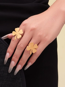 Close-up of golden clover ring set with brushed texture finish on model hand