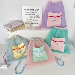 Detailed view of lightweight mesh drawstring backpacks in four vibrant contrast colors