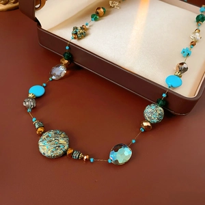 Detailed close-up of beaded necklace featuring turquoise and faceted green crystal beads