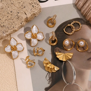 Artistic gold-plated geometric petal earrings and pearl studs on aesthetic background