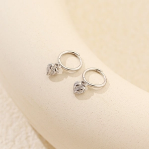 Macro view of S925 silver heart hoop earrings with pavé set sparkling zircon stones