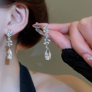 Detailed view of silver-plated leaf and teardrop tassel earrings with sparkling zircons