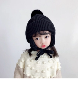 Detailed knit texture and warm ear flaps of a black winter hat for children
