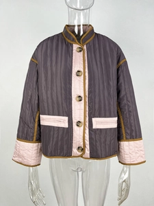 Close-up of quilted winter jacket with contrast trim and amber button details