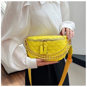 Detail of yellow quilted chest bag featuring triple gold chains and matching fabric strap