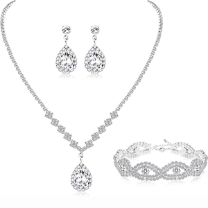 Detailed view of silver bridal jewelry set with teardrop zircons and wave pattern bracelet