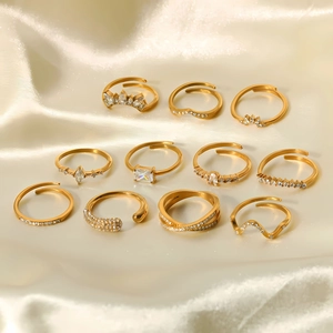 Détail d'un ensemble de 11 bagues dorées 18K avec zircons sur fond de soie élégant