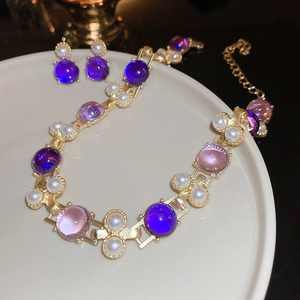Détail de l'ensemble collier et boucles d'oreilles vintage en or avec cristaux et perles