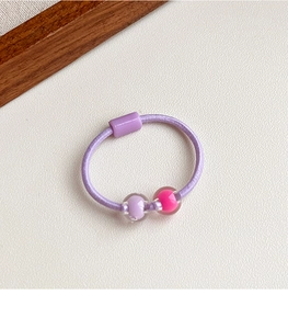 Vista dettagliata di elastico per capelli viola con perline decorative trasparenti