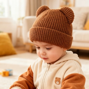 Close-up of thick knitted baby hat in caramel brown with 3D bear ears and ribbed texture